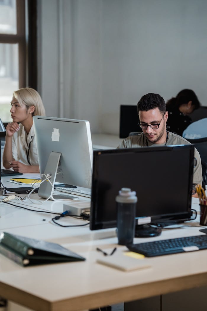 Modern office space with diverse team working diligently at desks.